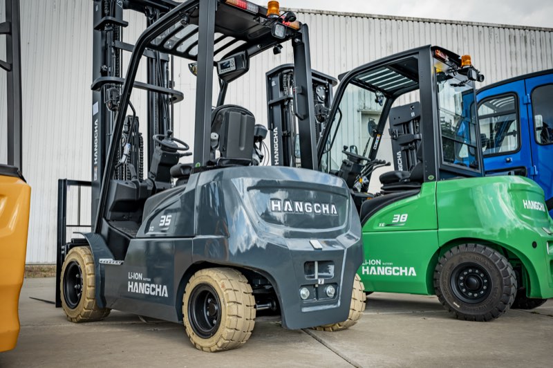 Blauwe, grijze en groene Hangcha heftrucks naast elkaar op het terrein