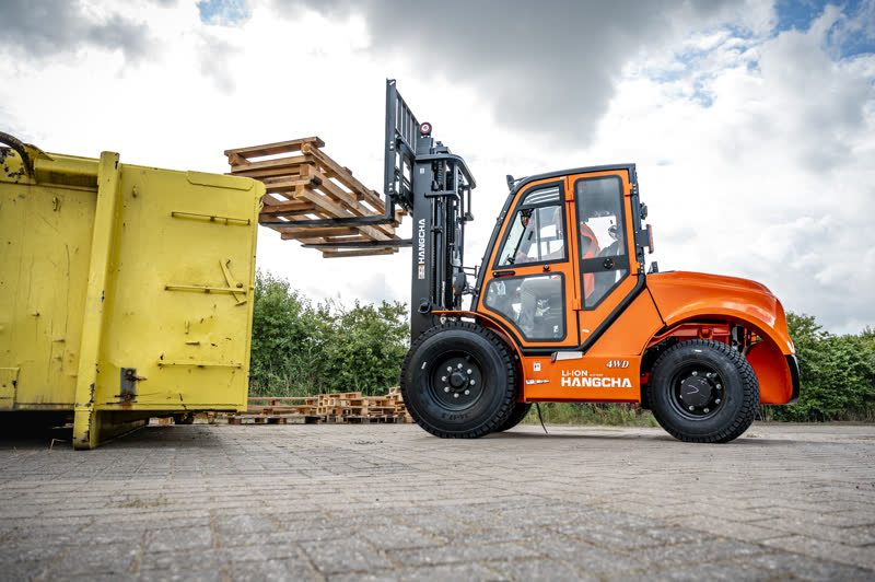 Oranje elektrische Hangcha RT tilt houten pallets op een buitenterrein